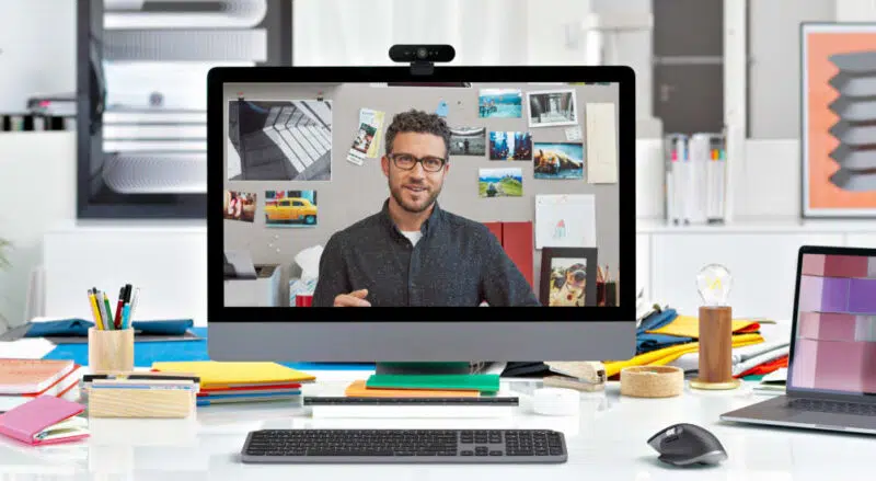 Logitech BRIO 4K Ultra HD Webcam mounted on a desktop monitor during a video call.