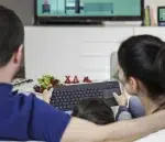 Logitech K400 Plus wireless touch keyboard held by a family while watching TV.