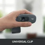 Logitech C270 HD Webcam held in hand, featuring a universal clip and 720p lens.